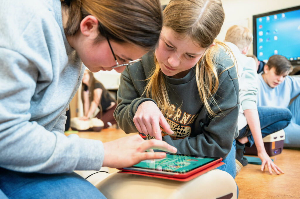2 leerlingen leren animeren op een pop met een tablet en de hartveilige school game.